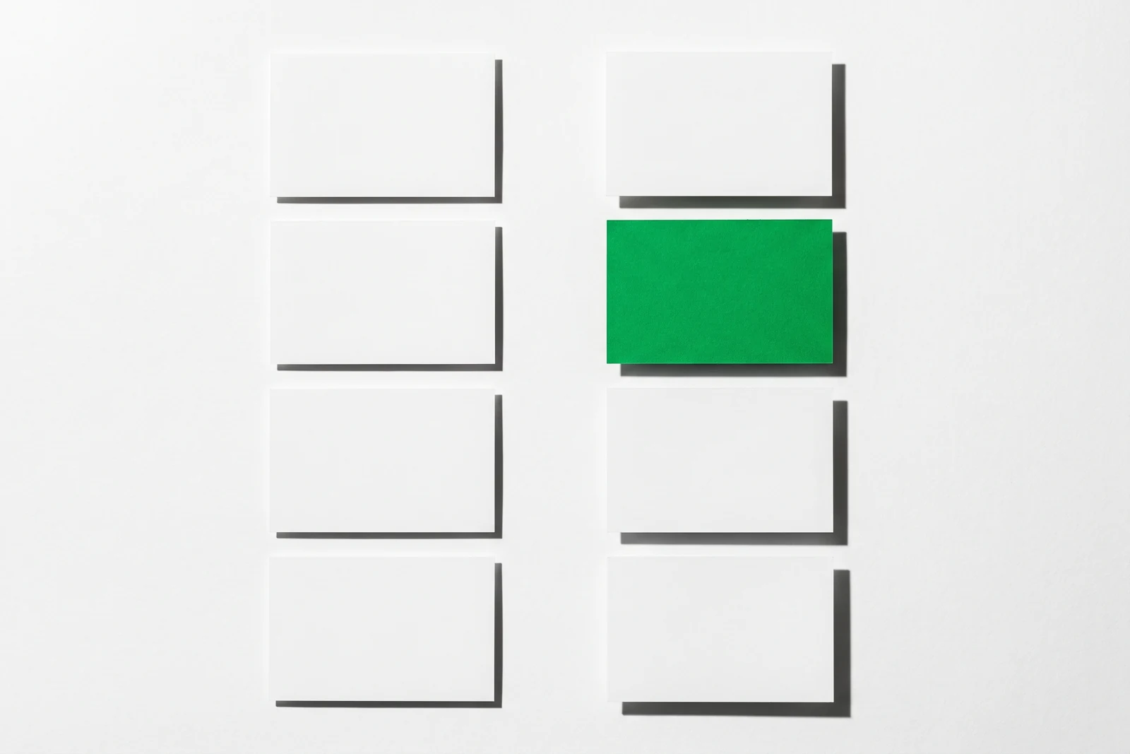 Huit cartes de papier disposées en deux colonnes qui se font face, une seule en vert